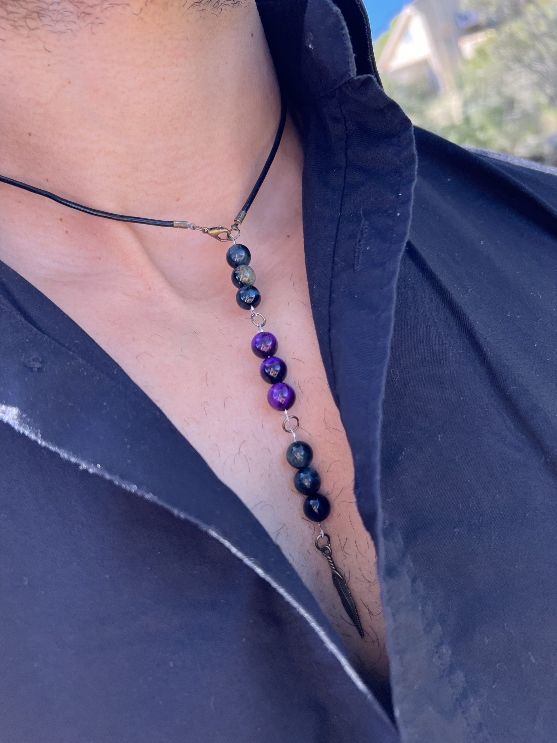 Collier Unisexe KIM Découvrez l'exclusivité du Collier Unisexe KIM - Une œuvre d'art repositionnable et ajustable pour homme et femme. Le Collier KIM se distingue par sa polyvalence exceptionnelle, conçu pour s'adapter à vos besoins et à votre style unique. Que vous préfériez un look avec un pendentif long, mi-long ou court, le Collier KIM vous offre une flexibilité totale. Sa fermeture intelligente permet de repositionner le bijou à plusieurs endroits, vous permettant ainsi de jouer avec la taille et le style, faisant de ce collier un accessoire pratique, modifiable et véritablement hors du commun. Fabriqué avec une lanière en cuir noir de haute qualité, le Collier KIM est orné d'œil de faucon et d'œil de tigre violet, des pierres semi-précieuses reconnues pour leurs propriétés bénéfiques. L'œil de faucon est réputé pour stimuler la clarté mentale, tandis que l'œil de tigre violet est associé à la protection et à l'équilibre émotionnel. La breloque de plume en bronze ajoute une touche d'élégance et de sophistication, faisant du Collier KIM bien plus qu'un simple accessoire. Collier Unisexe KIM Ce bijou unisexe KIM peut être commandé pour les deux genres, permettant un partage harmonieux. De plus, la possibilité de personnaliser les couleurs et de superposer d'autres colliers de la collection offre une infinité de combinaisons pour exprimer votre style personnel. Explorez le Collier KIM et dévoilez votre style unique, que ce soit pour une soirée chic, une journée décontractée ou un événement spécial. Avec ses pierres semi-précieuses aux vertus reconnues, ce bijou est bien plus qu'un simple accessoire de mode - c'est une déclaration de votre individualité et de votre bien-être. Commandez dès maintenant et plongez dans l'univers captivant du Collier Unisexe KIM. Exprimez-vous, soyez unique, soyez KIM !