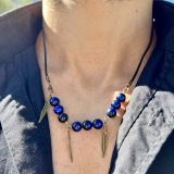 Collier de protection au style indien, les plumes bronze et lanière en cuir noir. Repositionnable, ajustable et élégant. Accessoire homme particulièrement raffiné et léger.