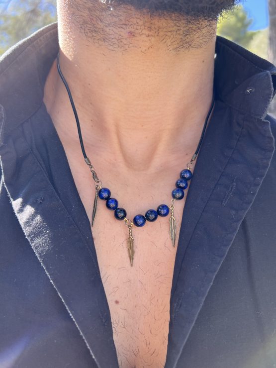 Collier de protection au style indien, les plumes bronze et lanière en cuir noir. Repositionnable, ajustable et élégant. Accessoire homme particulièrement raffiné et léger.