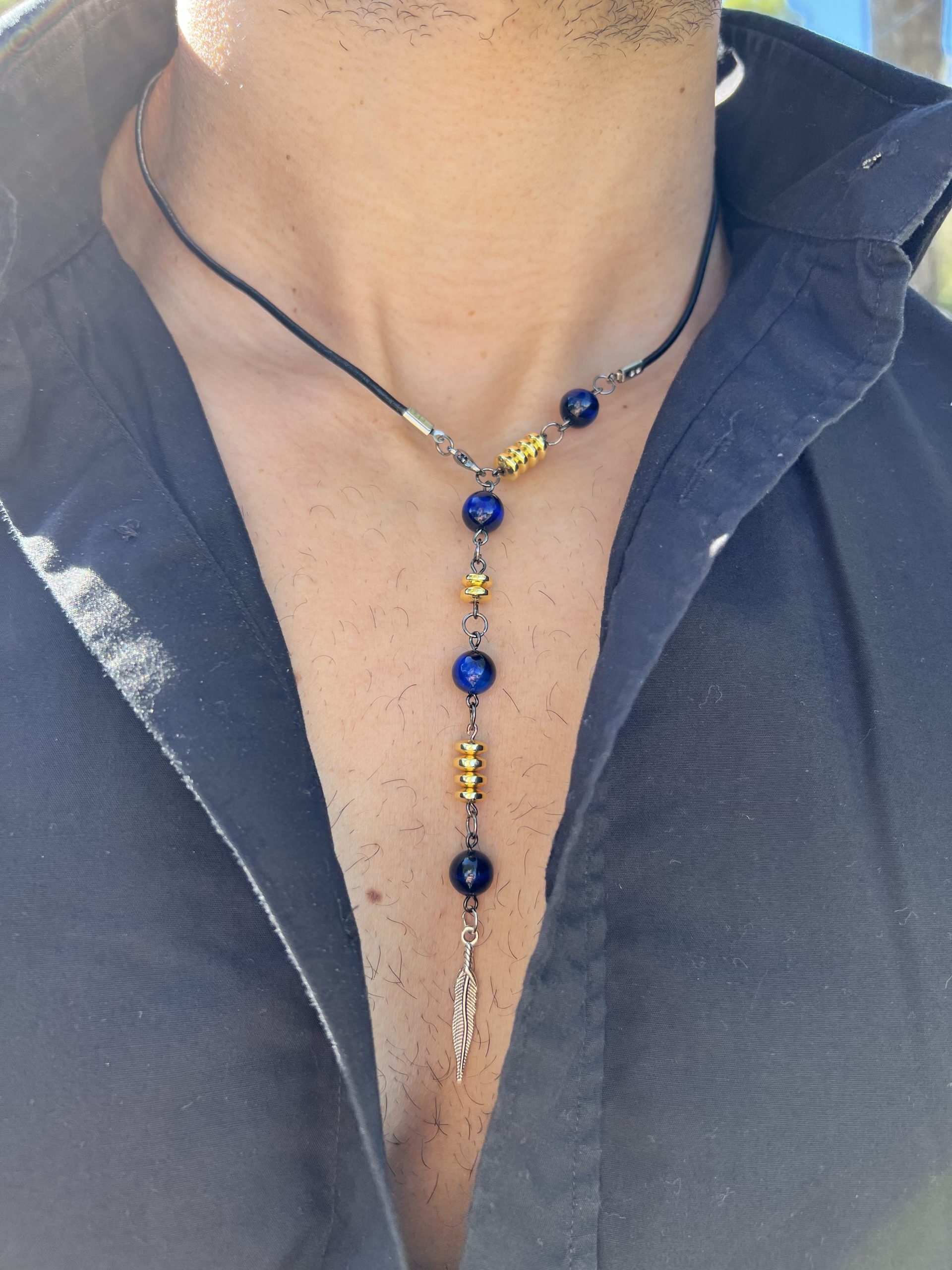 Collier Via avec l'oeil de tigre beu de lapis lazuli, oeil de tigre bleu foncé, les entretoises dorées et plume agentée