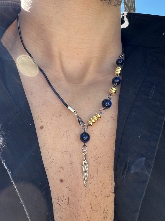 Collier Via avec l'oeil de tigre beu de lapis lazuli, oeil de tigre bleu foncé, les entretoises dorées et plume agentée