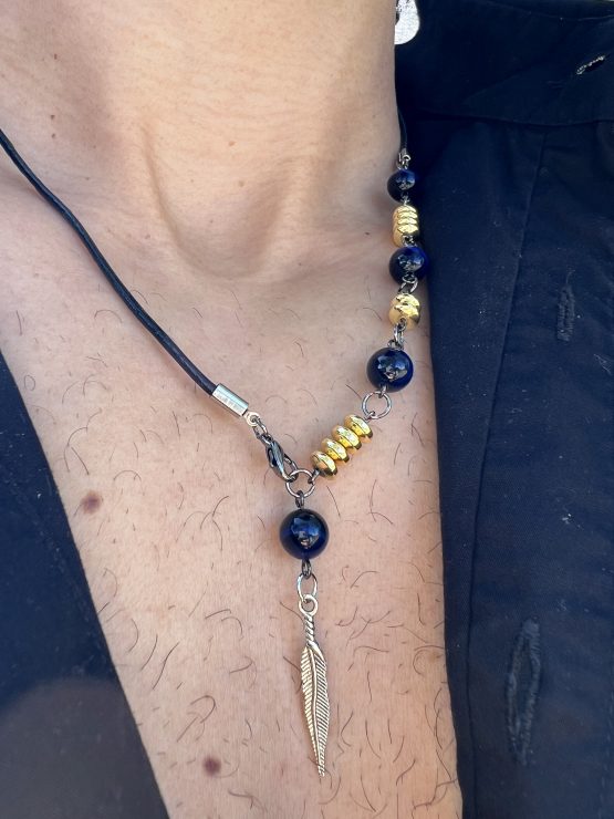 Collier Via avec l'oeil de tigre beu de lapis lazuli, oeil de tigre bleu foncé, les entretoises dorées et plume agentée