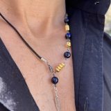 Collier Via avec l'oeil de tigre beu de lapis lazuli, oeil de tigre bleu foncé, les entretoises dorées et plume agentée