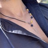 Collier Via avec l'oeil de tigre beu de lapis lazuli, oeil de tigre bleu foncé, les entretoises dorées et plume agentée