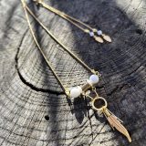 Découvrez le Collier Soe Ari une pièce de bijouterie exceptionnelle qui allie élégance, polyvalence et bienfaits énergétiques. Conçu par Jana Kuzmi, artiste peintre et fondatrice de la marque Boucle Bel Air, ce collier ajustable en longueur offre une infinité de possibilités de style. Grâce à sa perle coulissante, il peut être porté en ras de cou, en collier classique ou en sautoir, s'adaptant ainsi à toutes les occasions et à tous les looks. Collier Soe Ari se distingue par son design ingénieux qui permet de le porter à l'envers, offrant ainsi une toute nouvelle esthétique. Doté d'un pendentif composé de perles et de fines perles en coquillages suspendues et ornées d'une plume dorée, ce bijou est une véritable œuvre d'art. De plus, les finitions du dos du collier, avec deux chaînes ornées de plumes dorées et de perles d'agate blanches plus petites, ajoutent une touche de sophistication et de raffinement. Mais le Collier Soe Ari ne se contente pas d'être beau, il offre également des bienfaits sur le plan énergétique grâce à l'agate blanche. Connue pour ses propriétés de guérison et d'équilibre, l'agate blanche aide à dissiper le stress et à favoriser un sentiment de calme intérieur. En portant ce collier, vous bénéficiez donc non seulement d'un accessoire de mode exceptionnel, mais aussi d'un véritable allié pour votre bien-être. Fabriqué avec soin à partir d'agate blanche brillante, de perles plates polies en coquillages et d'une chaîne en acier inoxydable doré, le Collier Soe Ari incarne le savoir-faire artisanal et la qualité supérieure. Chaque détail a été pensé pour offrir une expérience unique à celui ou celle qui le porte.Offrez-vous dès maintenant le plaisir de posséder un bijou aussi spécial que vous avec le Collier Soe Ari. Que ce soit pour une occasion spéciale ou pour égayer votre tenue quotidienne, ce collier polyvalent saura vous accompagner avec style et élégance.
