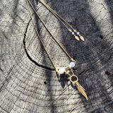 Découvrez le Collier Soe Ari une pièce de bijouterie exceptionnelle qui allie élégance, polyvalence et bienfaits énergétiques. Conçu par Jana Kuzmi, artiste peintre et fondatrice de la marque Boucle Bel Air, ce collier ajustable en longueur offre une infinité de possibilités de style. Grâce à sa perle coulissante, il peut être porté en ras de cou, en collier classique ou en sautoir, s'adaptant ainsi à toutes les occasions et à tous les looks. Collier Soe Ari se distingue par son design ingénieux qui permet de le porter à l'envers, offrant ainsi une toute nouvelle esthétique. Doté d'un pendentif composé de perles et de fines perles en coquillages suspendues et ornées d'une plume dorée, ce bijou est une véritable œuvre d'art. De plus, les finitions du dos du collier, avec deux chaînes ornées de plumes dorées et de perles d'agate blanches plus petites, ajoutent une touche de sophistication et de raffinement. Mais le Collier Soe Ari ne se contente pas d'être beau, il offre également des bienfaits sur le plan énergétique grâce à l'agate blanche. Connue pour ses propriétés de guérison et d'équilibre, l'agate blanche aide à dissiper le stress et à favoriser un sentiment de calme intérieur. En portant ce collier, vous bénéficiez donc non seulement d'un accessoire de mode exceptionnel, mais aussi d'un véritable allié pour votre bien-être. Fabriqué avec soin à partir d'agate blanche brillante, de perles plates polies en coquillages et d'une chaîne en acier inoxydable doré, le Collier Soe Ari incarne le savoir-faire artisanal et la qualité supérieure. Chaque détail a été pensé pour offrir une expérience unique à celui ou celle qui le porte.Offrez-vous dès maintenant le plaisir de posséder un bijou aussi spécial que vous avec le Collier Soe Ari. Que ce soit pour une occasion spéciale ou pour égayer votre tenue quotidienne, ce collier polyvalent saura vous accompagner avec style et élégance.