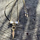 Découvrez le Collier Soe Ari une pièce de bijouterie exceptionnelle qui allie élégance, polyvalence et bienfaits énergétiques. Conçu par Jana Kuzmi, artiste peintre et fondatrice de la marque Boucle Bel Air, ce collier ajustable en longueur offre une infinité de possibilités de style. Grâce à sa perle coulissante, il peut être porté en ras de cou, en collier classique ou en sautoir, s'adaptant ainsi à toutes les occasions et à tous les looks. Collier Soe Ari se distingue par son design ingénieux qui permet de le porter à l'envers, offrant ainsi une toute nouvelle esthétique. Doté d'un pendentif composé de perles et de fines perles en coquillages suspendues et ornées d'une plume dorée, ce bijou est une véritable œuvre d'art. De plus, les finitions du dos du collier, avec deux chaînes ornées de plumes dorées et de perles d'agate blanches plus petites, ajoutent une touche de sophistication et de raffinement. Mais le Collier Soe Ari ne se contente pas d'être beau, il offre également des bienfaits sur le plan énergétique grâce à l'agate blanche. Connue pour ses propriétés de guérison et d'équilibre, l'agate blanche aide à dissiper le stress et à favoriser un sentiment de calme intérieur. En portant ce collier, vous bénéficiez donc non seulement d'un accessoire de mode exceptionnel, mais aussi d'un véritable allié pour votre bien-être. Fabriqué avec soin à partir d'agate blanche brillante, de perles plates polies en coquillages et d'une chaîne en acier inoxydable doré, le Collier Soe Ari incarne le savoir-faire artisanal et la qualité supérieure. Chaque détail a été pensé pour offrir une expérience unique à celui ou celle qui le porte.Offrez-vous dès maintenant le plaisir de posséder un bijou aussi spécial que vous avec le Collier Soe Ari. Que ce soit pour une occasion spéciale ou pour égayer votre tenue quotidienne, ce collier polyvalent saura vous accompagner avec style et élégance.