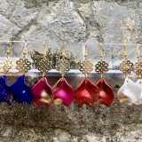 Boucles d’oreilles Flavie Découvrez les boucles d’oreilles “Flavie”, des bijoux fantaisie uniques en leur genre. Déclinées en plusieurs couleurs tendance  – blanc mat, rose métallisé, vert foncé métallisé, bleu royal mat, rouge métallisé et or – elles offrent une touche de raffinement avec leurs projections de couleur or, appliquées à la main pour une finition singulière sur chaque paire. Le design inclut un élément doré élégant et une pétale suspendue de couleur tachetée or, rendant ces boucles d’oreilles idéales pour compléter vos tenues au quotidien ou pour des occasions spéciales. Créées par l’artiste Jana Kuzmi, elles représentent un accessoire original et de qualité qui saura se démarquer dans votre collection de bijoux.
