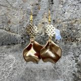 Boucles d’oreilles Flavie Découvrez les boucles d’oreilles “Flavie”, des bijoux fantaisie uniques en leur genre. Déclinées en plusieurs couleurs tendance  – blanc mat, rose métallisé, vert foncé métallisé, bleu royal mat, rouge métallisé et or – elles offrent une touche de raffinement avec leurs projections de couleur or, appliquées à la main pour une finition singulière sur chaque paire. Le design inclut un élément doré élégant et une pétale suspendue de couleur tachetée or, rendant ces boucles d’oreilles idéales pour compléter vos tenues au quotidien ou pour des occasions spéciales. Créées par l’artiste Jana Kuzmi, elles représentent un accessoire original et de qualité qui saura se démarquer dans votre collection de bijoux.