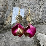 Boucles d’oreilles Flavie Découvrez les boucles d’oreilles “Flavie”, des bijoux fantaisie uniques en leur genre. Déclinées en plusieurs couleurs tendance  – blanc mat, rose métallisé, vert foncé métallisé, bleu royal mat, rouge métallisé et or – elles offrent une touche de raffinement avec leurs projections de couleur or, appliquées à la main pour une finition singulière sur chaque paire. Le design inclut un élément doré élégant et une pétale suspendue de couleur tachetée or, rendant ces boucles d’oreilles idéales pour compléter vos tenues au quotidien ou pour des occasions spéciales. Créées par l’artiste Jana Kuzmi, elles représentent un accessoire original et de qualité qui saura se démarquer dans votre collection de bijoux.