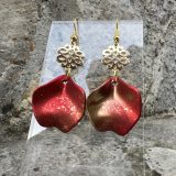 Boucles d’oreilles Flavie Découvrez les boucles d’oreilles “Flavie”, des bijoux fantaisie uniques en leur genre. Déclinées en plusieurs couleurs tendance  – blanc mat, rose métallisé, vert foncé métallisé, bleu royal mat, rouge métallisé et or – elles offrent une touche de raffinement avec leurs projections de couleur or, appliquées à la main pour une finition singulière sur chaque paire. Le design inclut un élément doré élégant et une pétale suspendue de couleur tachetée or, rendant ces boucles d’oreilles idéales pour compléter vos tenues au quotidien ou pour des occasions spéciales. Créées par l’artiste Jana Kuzmi, elles représentent un accessoire original et de qualité qui saura se démarquer dans votre collection de bijoux.