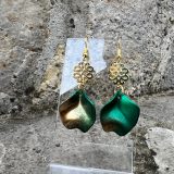 Boucles d’oreilles Flavie Découvrez les boucles d’oreilles “Flavie”, des bijoux fantaisie uniques en leur genre. Déclinées en plusieurs couleurs tendance  – blanc mat, rose métallisé, vert foncé métallisé, bleu royal mat, rouge métallisé et or – elles offrent une touche de raffinement avec leurs projections de couleur or, appliquées à la main pour une finition singulière sur chaque paire. Le design inclut un élément doré élégant et une pétale suspendue de couleur tachetée or, rendant ces boucles d’oreilles idéales pour compléter vos tenues au quotidien ou pour des occasions spéciales. Créées par l’artiste Jana Kuzmi, elles représentent un accessoire original et de qualité qui saura se démarquer dans votre collection de bijoux.