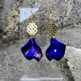Boucles d’oreilles Flavie Découvrez les boucles d’oreilles “Flavie”, des bijoux fantaisie uniques en leur genre. Déclinées en plusieurs couleurs tendance  – blanc mat, rose métallisé, vert foncé métallisé, bleu royal mat, rouge métallisé et or – elles offrent une touche de raffinement avec leurs projections de couleur or, appliquées à la main pour une finition singulière sur chaque paire. Le design inclut un élément doré élégant et une pétale suspendue de couleur tachetée or, rendant ces boucles d’oreilles idéales pour compléter vos tenues au quotidien ou pour des occasions spéciales. Créées par l’artiste Jana Kuzmi, elles représentent un accessoire original et de qualité qui saura se démarquer dans votre collection de bijoux.
