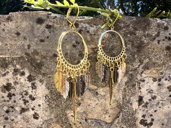 Boucles d'oreilles - Attrape rêve Boucles d'oreilles artisanales avec plumes colorées/teintes dorées et argentées – Attrape-rêves fait main par Jana Kuzmi | Boucle Bel Air Découvrez nos magnifiques boucles d'oreilles artisanales, conçues avec soin par l'artiste Jana Kuzmi sous la marque Boucle Bel Air. Chaque paire met en valeur des plumes dures de différentes couleurs, attachées à un cercle qui forme un attrape-rêves unique et élégant. Parfaites pour ajouter une touche bohème et colorée à votre style, ces boucles d'oreilles faites main sont idéales pour les amoureux de l'artisanat et de la mode éthique. Boucles d'oreilles - Attrape rêve Offrez-vous un accessoire original, léger et plein de charme, qui reflète la créativité et le savoir-faire de Jana Kuzmi. Caractéristiques principales : Création artisanale par Jana Kuzmi Design attrape-rêves avec plumes colorées Boucles d'oreilles faites main Matériaux de qualité, plumes dures résistantes Idéal pour un style bohème, ethnique ou tendance Ajoutez une touche d'originalité à votre collection avec ces, Boucles d'oreilles - Attrape rêve, uniques, parfaites pour toutes les occasions. 