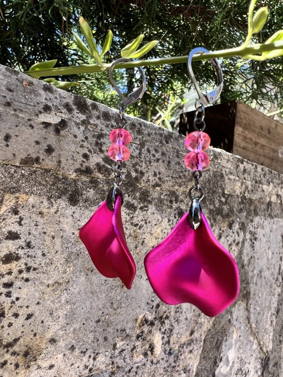 Boucles d'oreilles avec pétale rose métallisée et perles roses – Création de Jana Kuzmi pour Boucle Bel Air Apportez une touche de douceur et d'élégance à votre style avec ces magnifiques boucles d'oreilles pendantes, entièrement faites main par l'artiste peintre et créatrice de bijoux Jana Kuzmi, sous la marque Boucle Bel Air. Chaque paire se distingue par une pétale en métal rose métallisé, délicatement travaillée pour refléter la lumière et créer un effet sophistiqué. Suspendues à une attache sécurisée en acier inoxydable gris foncé, elles offrent à la fois confort et durabilité. Deux perles roses suspendues viennent compléter l'ensemble, apportant une note de féminité et de romantisme à ces bijoux uniques. Leur design bohème chic en fait un accessoire parfait pour sublimer vos tenues lors d'événements spéciaux ou pour une allure quotidienne élégante. Boucles d'oreilles avec pétale rose métallisée et perles roses Caractéristiques principales : Création artisanale par Jana Kuzmi Boucles d'oreilles pendantes en métal rose métallisé Deux perles roses suspendues pour une touche raffinée Attache sécurisée en acier inoxydable gris foncé, hypoallergénique et résistante Style bohème chic, fait main, idéal pour une allure élégante et tendance Offrez-vous ou offrez à un proche cette pièce unique, symbole de créativité et de savoir-faire artisanal. Un bijou qui allie finesse, originalité et élégance, signé par l’artiste Jana Kuzmi et présenté par Boucle Bel Air.