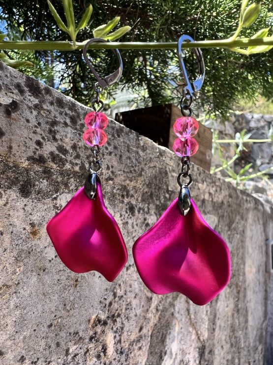 Boucles d'oreilles avec pétale rose métallisée et perles roses – Création de Jana Kuzmi pour Boucle Bel Air Apportez une touche de douceur et d'élégance à votre style avec ces magnifiques boucles d'oreilles pendantes, entièrement faites main par l'artiste peintre et créatrice de bijoux Jana Kuzmi, sous la marque Boucle Bel Air. Chaque paire se distingue par une pétale en métal rose métallisé, délicatement travaillée pour refléter la lumière et créer un effet sophistiqué. Suspendues à une attache sécurisée en acier inoxydable gris foncé, elles offrent à la fois confort et durabilité. Deux perles roses suspendues viennent compléter l'ensemble, apportant une note de féminité et de romantisme à ces bijoux uniques. Leur design bohème chic en fait un accessoire parfait pour sublimer vos tenues lors d'événements spéciaux ou pour une allure quotidienne élégante. Boucles d'oreilles avec pétale rose métallisée et perles roses Caractéristiques principales : Création artisanale par Jana Kuzmi Boucles d'oreilles pendantes en métal rose métallisé Deux perles roses suspendues pour une touche raffinée Attache sécurisée en acier inoxydable gris foncé, hypoallergénique et résistante Style bohème chic, fait main, idéal pour une allure élégante et tendance Offrez-vous ou offrez à un proche cette pièce unique, symbole de créativité et de savoir-faire artisanal. Un bijou qui allie finesse, originalité et élégance, signé par l’artiste Jana Kuzmi et présenté par Boucle Bel Air.