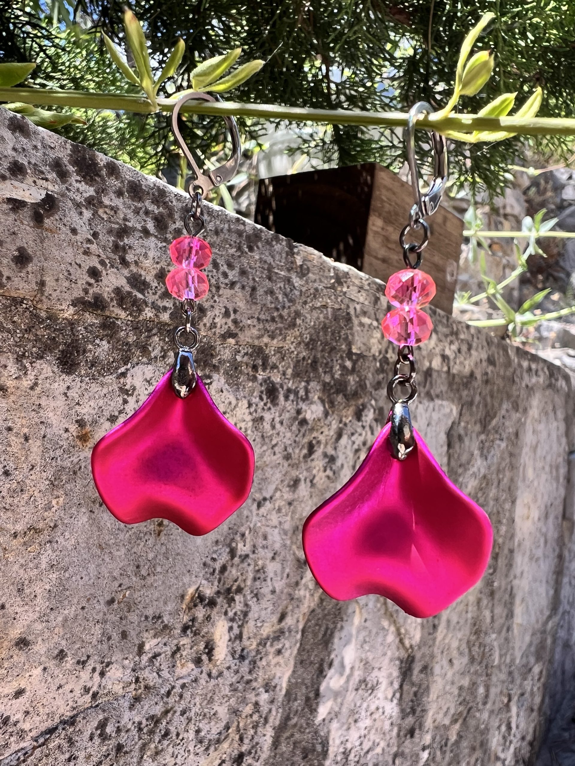 Boucles d'oreilles avec pétale rose métallisée et perles roses – Création de Jana Kuzmi pour Boucle Bel Air Apportez une touche de douceur et d'élégance à votre style avec ces magnifiques boucles d'oreilles pendantes, entièrement faites main par l'artiste peintre et créatrice de bijoux Jana Kuzmi, sous la marque Boucle Bel Air. Chaque paire se distingue par une pétale en métal rose métallisé, délicatement travaillée pour refléter la lumière et créer un effet sophistiqué. Suspendues à une attache sécurisée en acier inoxydable gris foncé, elles offrent à la fois confort et durabilité. Deux perles roses suspendues viennent compléter l'ensemble, apportant une note de féminité et de romantisme à ces bijoux uniques. Leur design bohème chic en fait un accessoire parfait pour sublimer vos tenues lors d'événements spéciaux ou pour une allure quotidienne élégante. Boucles d'oreilles avec pétale rose métallisée et perles roses Caractéristiques principales : Création artisanale par Jana Kuzmi Boucles d'oreilles pendantes en métal rose métallisé Deux perles roses suspendues pour une touche raffinée Attache sécurisée en acier inoxydable gris foncé, hypoallergénique et résistante Style bohème chic, fait main, idéal pour une allure élégante et tendance Offrez-vous ou offrez à un proche cette pièce unique, symbole de créativité et de savoir-faire artisanal. Un bijou qui allie finesse, originalité et élégance, signé par l’artiste Jana Kuzmi et présenté par Boucle Bel Air.