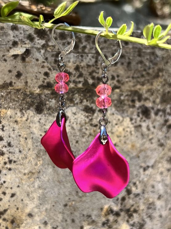 Boucles d'oreilles avec pétale rose métallisée et perles roses – Création de Jana Kuzmi pour Boucle Bel Air Apportez une touche de douceur et d'élégance à votre style avec ces magnifiques boucles d'oreilles pendantes, entièrement faites main par l'artiste peintre et créatrice de bijoux Jana Kuzmi, sous la marque Boucle Bel Air. Chaque paire se distingue par une pétale en métal rose métallisé, délicatement travaillée pour refléter la lumière et créer un effet sophistiqué. Suspendues à une attache sécurisée en acier inoxydable gris foncé, elles offrent à la fois confort et durabilité. Deux perles roses suspendues viennent compléter l'ensemble, apportant une note de féminité et de romantisme à ces bijoux uniques. Leur design bohème chic en fait un accessoire parfait pour sublimer vos tenues lors d'événements spéciaux ou pour une allure quotidienne élégante. Boucles d'oreilles avec pétale rose métallisée et perles roses Caractéristiques principales : Création artisanale par Jana Kuzmi Boucles d'oreilles pendantes en métal rose métallisé Deux perles roses suspendues pour une touche raffinée Attache sécurisée en acier inoxydable gris foncé, hypoallergénique et résistante Style bohème chic, fait main, idéal pour une allure élégante et tendance Offrez-vous ou offrez à un proche cette pièce unique, symbole de créativité et de savoir-faire artisanal. Un bijou qui allie finesse, originalité et élégance, signé par l’artiste Jana Kuzmi et présenté par Boucle Bel Air.