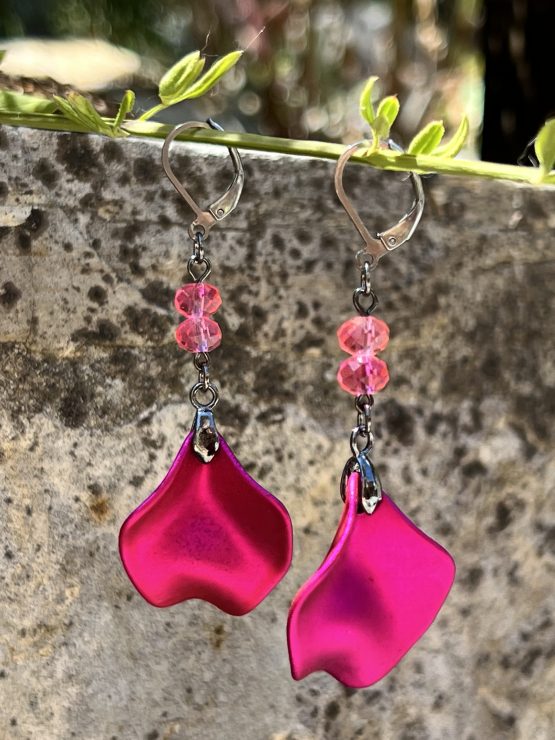 Boucles d'oreilles avec pétale rose métallisée et perles roses – Création de Jana Kuzmi pour Boucle Bel Air Apportez une touche de douceur et d'élégance à votre style avec ces magnifiques boucles d'oreilles pendantes, entièrement faites main par l'artiste peintre et créatrice de bijoux Jana Kuzmi, sous la marque Boucle Bel Air. Chaque paire se distingue par une pétale en métal rose métallisé, délicatement travaillée pour refléter la lumière et créer un effet sophistiqué. Suspendues à une attache sécurisée en acier inoxydable gris foncé, elles offrent à la fois confort et durabilité. Deux perles roses suspendues viennent compléter l'ensemble, apportant une note de féminité et de romantisme à ces bijoux uniques. Leur design bohème chic en fait un accessoire parfait pour sublimer vos tenues lors d'événements spéciaux ou pour une allure quotidienne élégante. Boucles d'oreilles avec pétale rose métallisée et perles roses Caractéristiques principales : Création artisanale par Jana Kuzmi Boucles d'oreilles pendantes en métal rose métallisé Deux perles roses suspendues pour une touche raffinée Attache sécurisée en acier inoxydable gris foncé, hypoallergénique et résistante Style bohème chic, fait main, idéal pour une allure élégante et tendance Offrez-vous ou offrez à un proche cette pièce unique, symbole de créativité et de savoir-faire artisanal. Un bijou qui allie finesse, originalité et élégance, signé par l’artiste Jana Kuzmi et présenté par Boucle Bel Air.